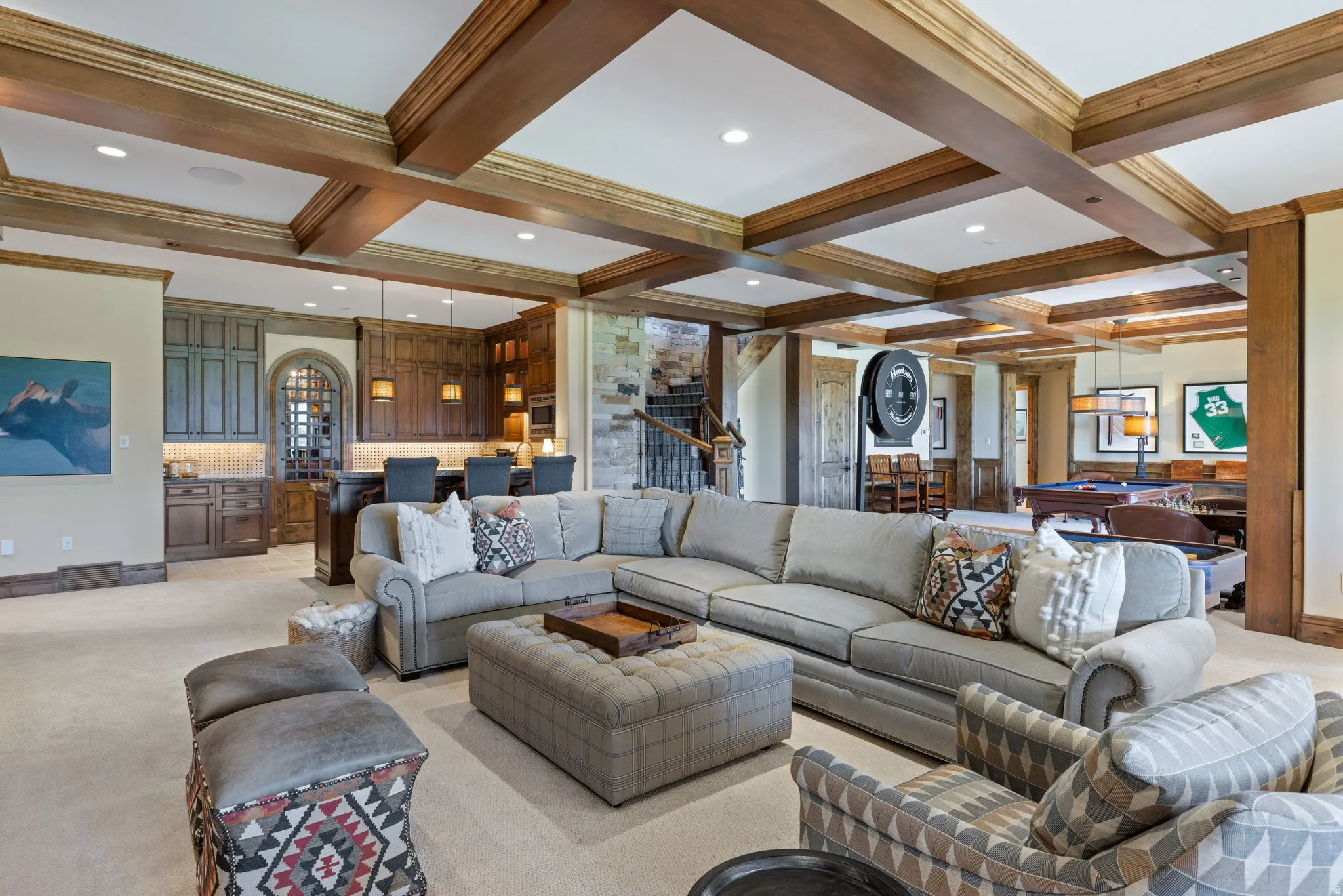 Expansive recreation space featuring exposed wood beam ceilings, a built-in wet bar with cabinetry, stone accents, and recessed lighting