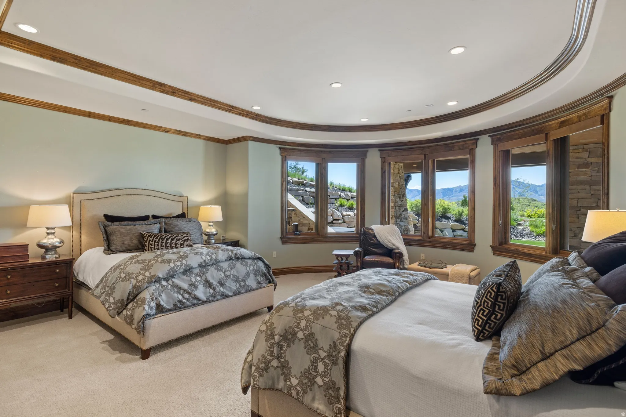 Carpeted interior with a curved wall of multiple windows featuring wood-frame trim