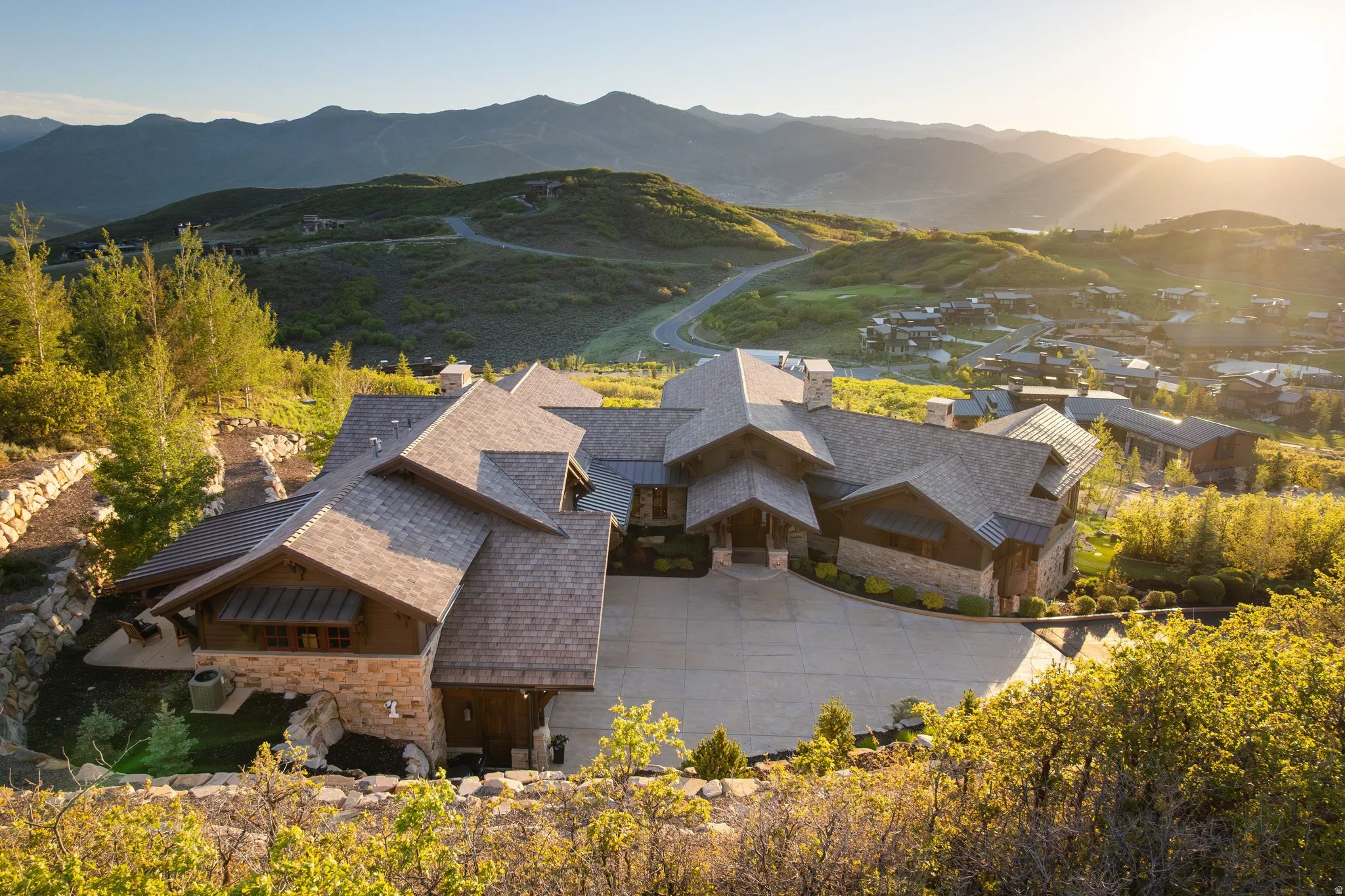 Expansive mountain residence featuring a multi-gabled shingle roof and stone and wood facade