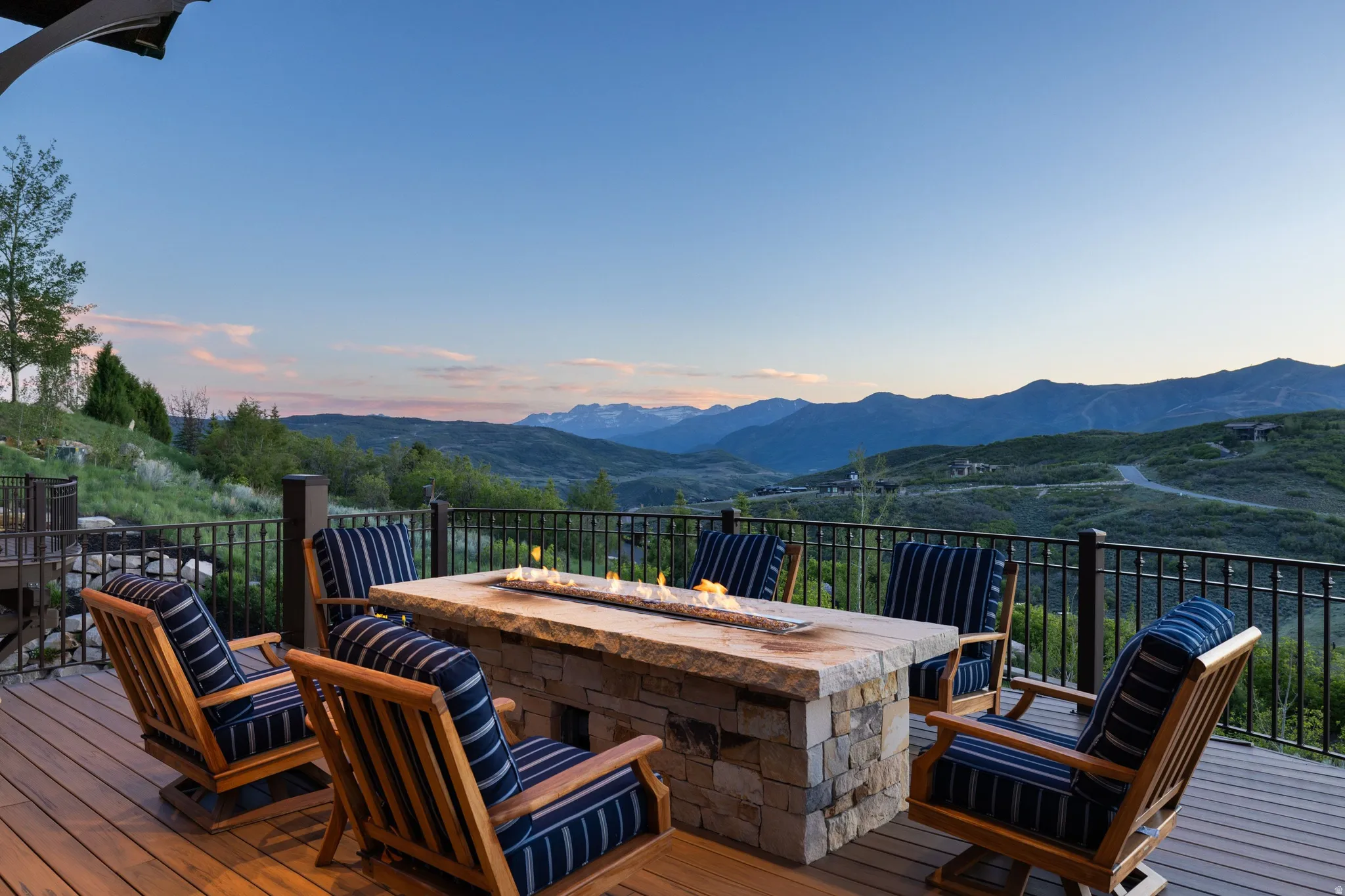 Expansive outdoor deck featuring a stone fire pit and dark wood-finish decking