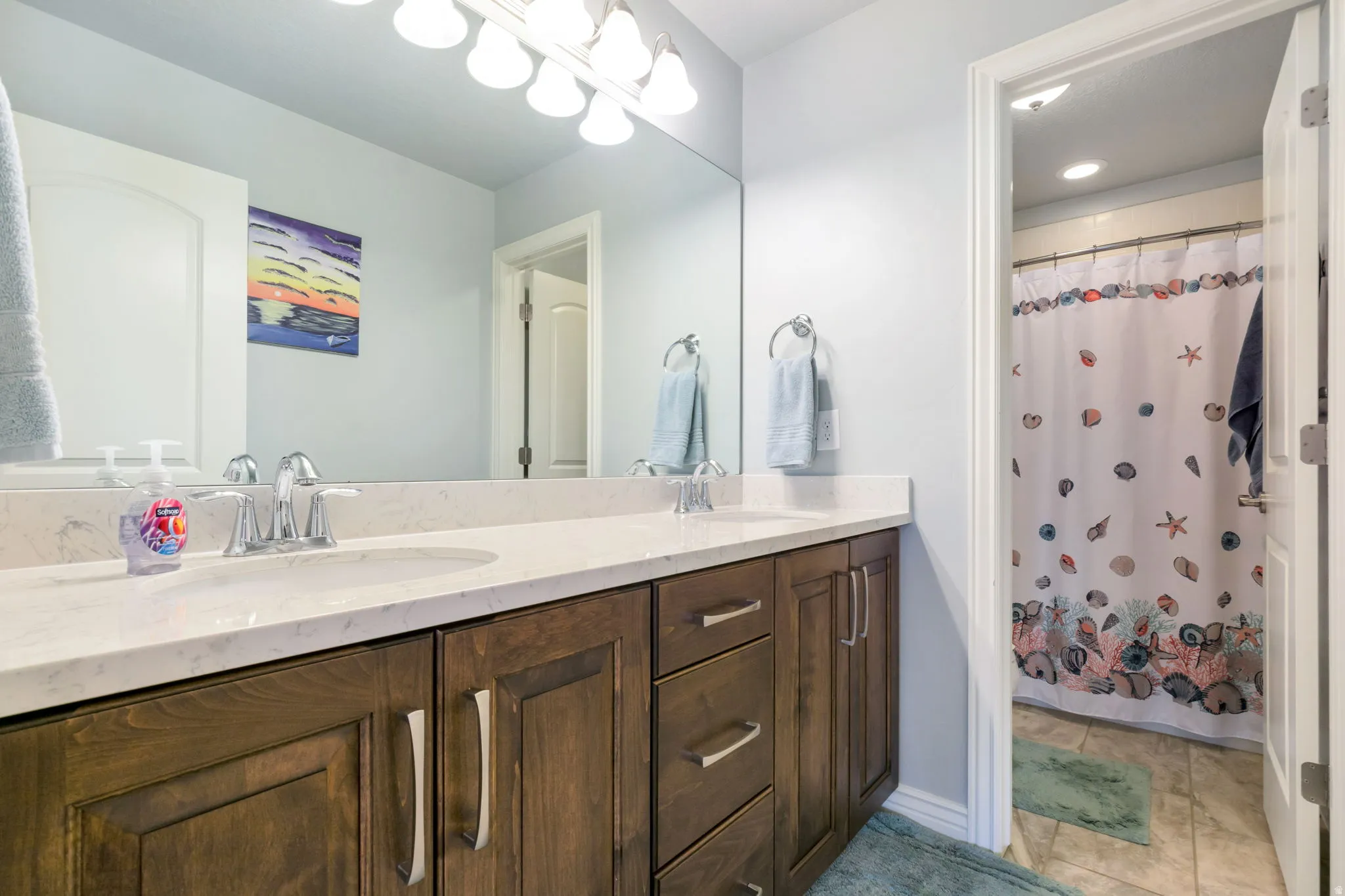 Double vanity with integrated sinks and chrome fixtures, set against a full-width mirror