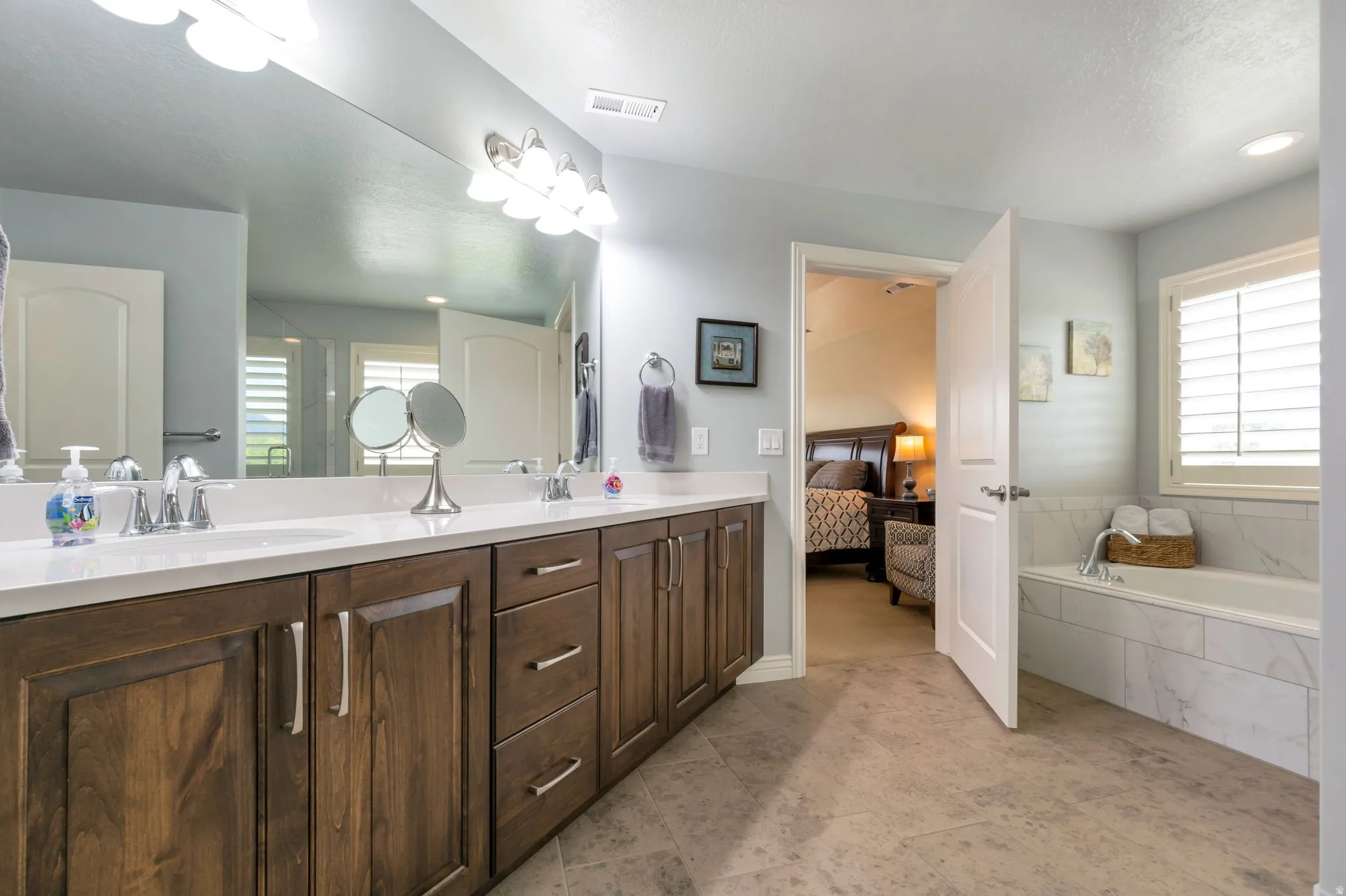 Double vanity with wood-finish cabinetry and white countertops
