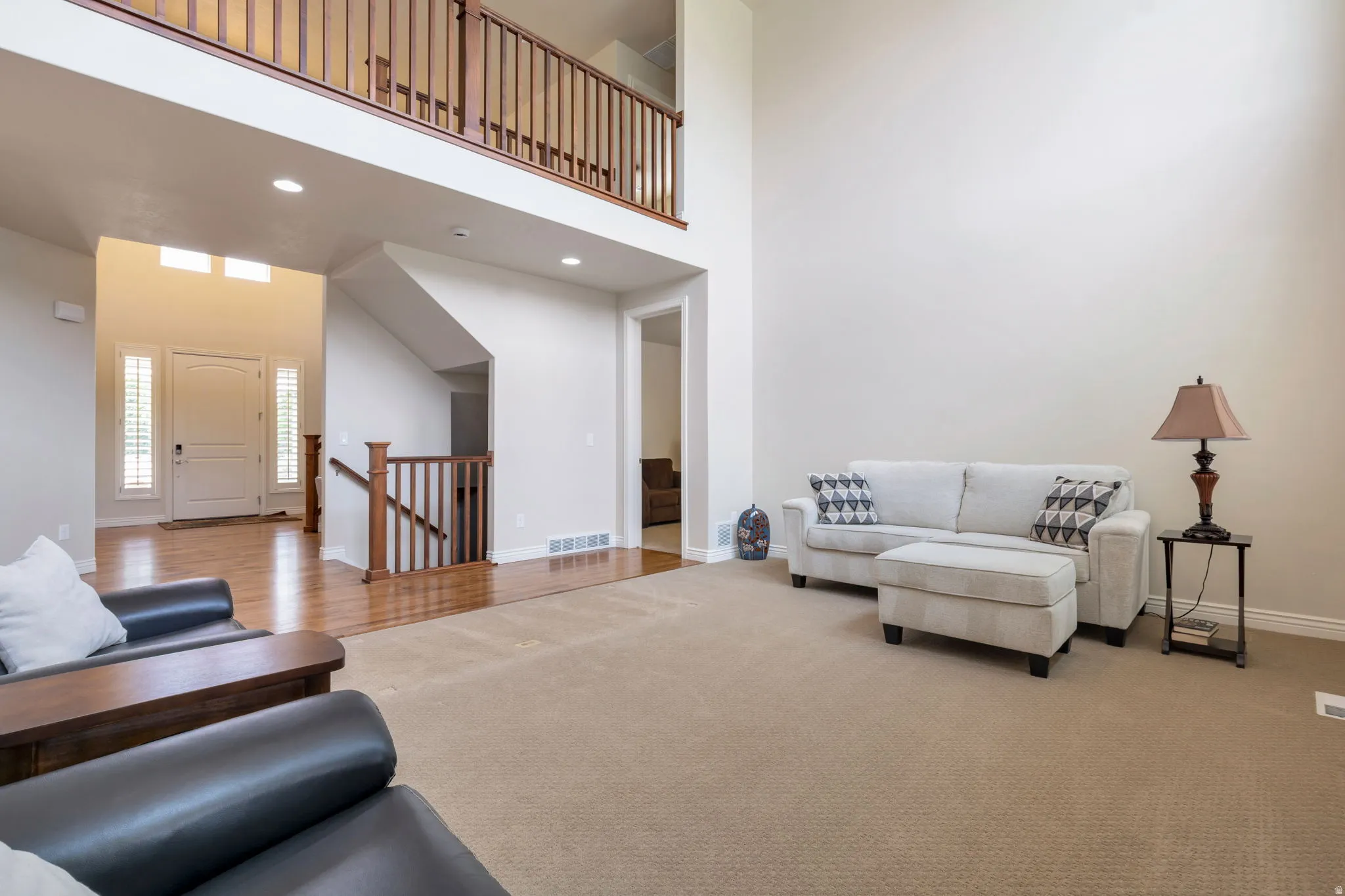 Two-story living area featuring a vaulted ceiling and recessed lighting