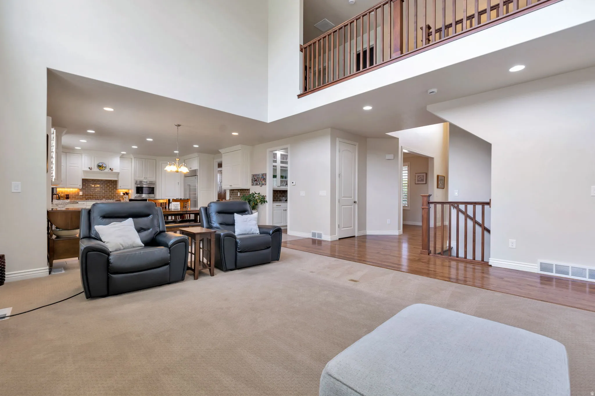 Two-story living area with high ceilings and a visible upper-level balcony