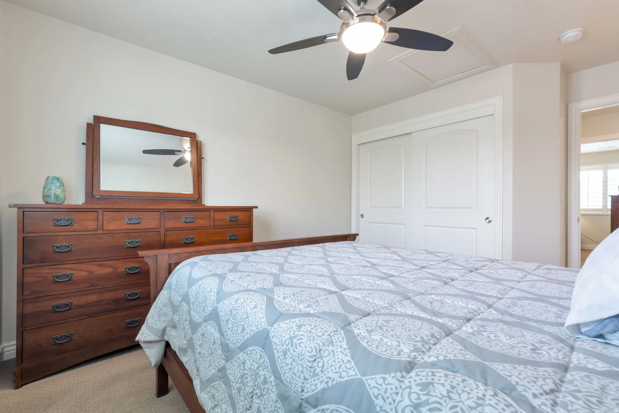 Neutral wall paint, ceiling fan with integrated lighting, and carpeted flooring