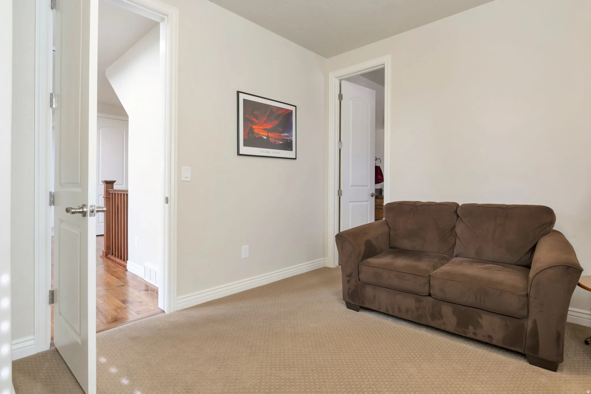 Carpeted room featuring a white baseboard trim and neutral wall paint