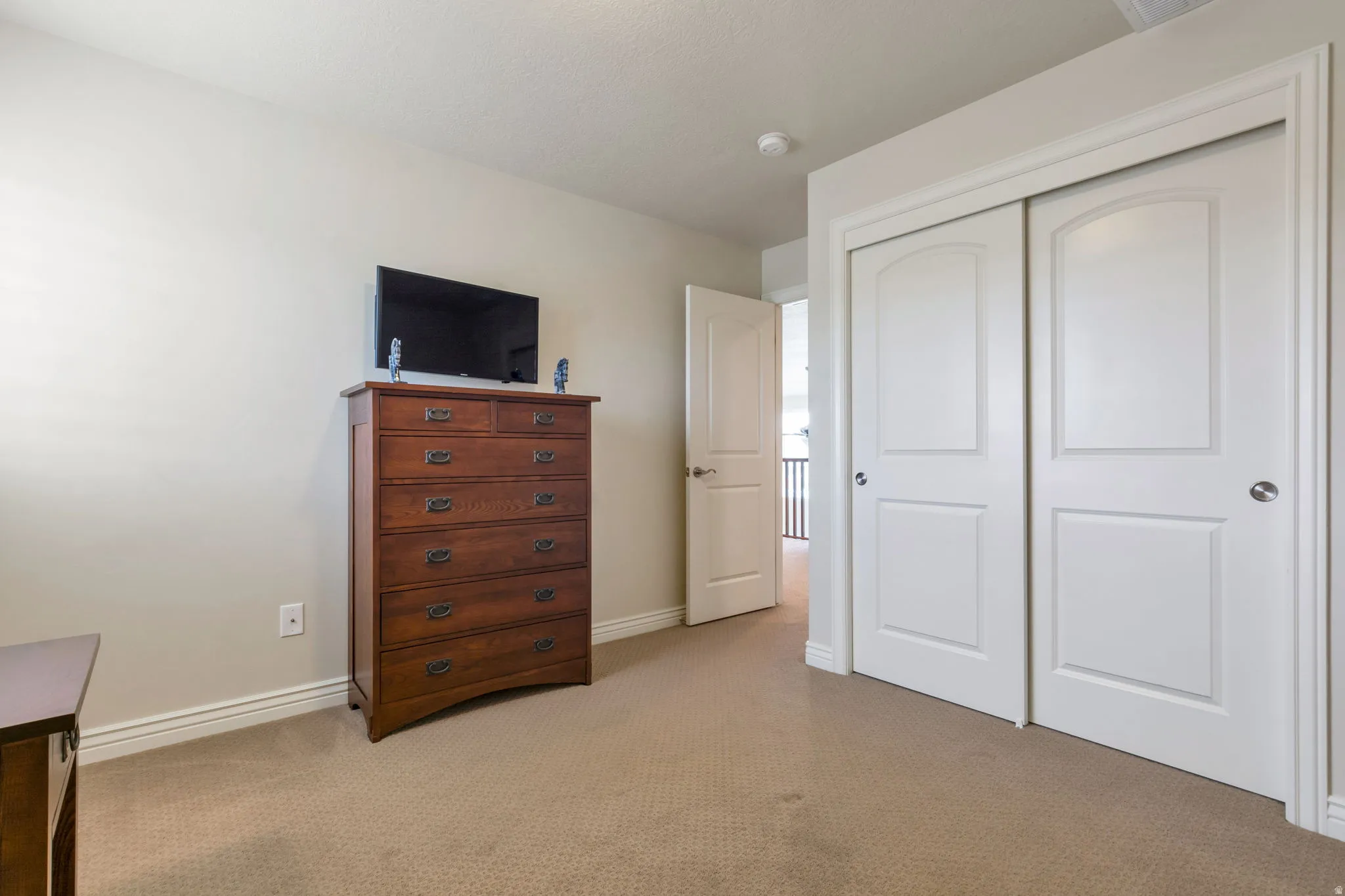 Bedroom featuring neutral wall paint, light-toned carpeting, and white trim