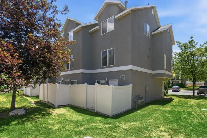 Multi-level exterior with gray stucco siding and white trim