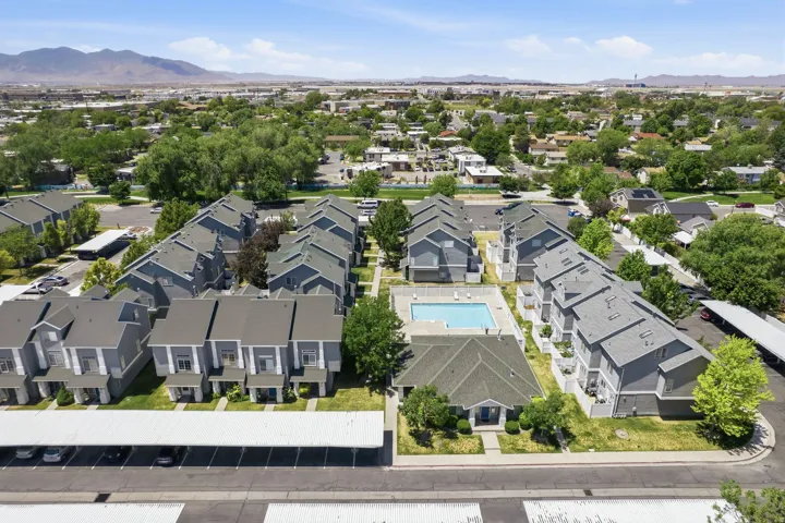 Aerial perspective showcasing a multi-building property featuring a central swimming pool and multiple carports