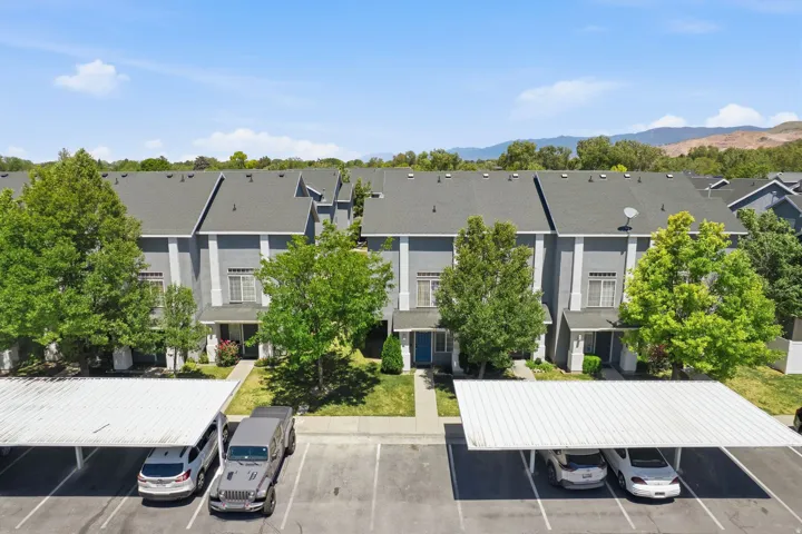 Townhome exterior featuring gray siding, white trim, and dark gray shingle roofing