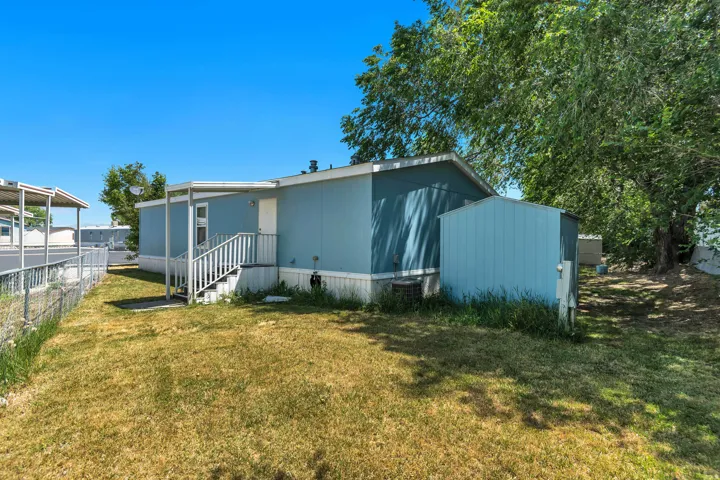 Light blue exterior with white trim, featuring a covered porch entryway and white staircase