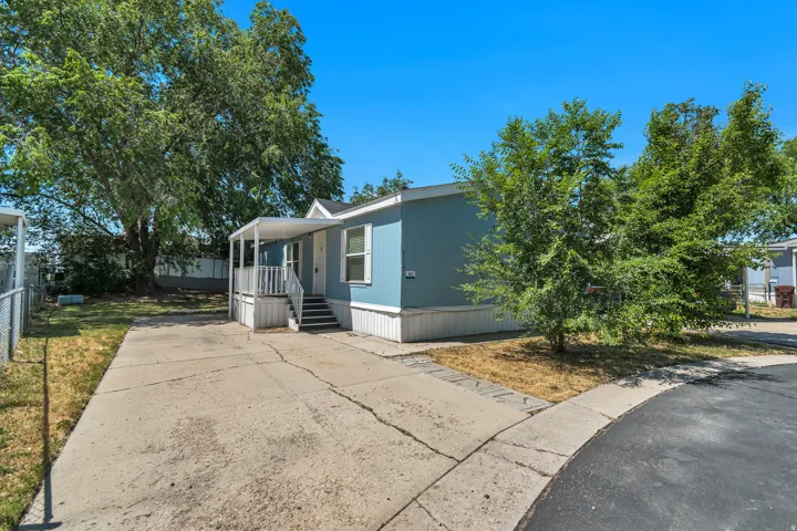 Light blue exterior with white trim and a covered front porch featuring white railings