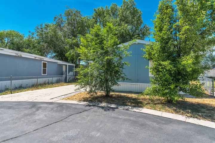 Light blue-sided manufactured home with white trim and a white-framed window