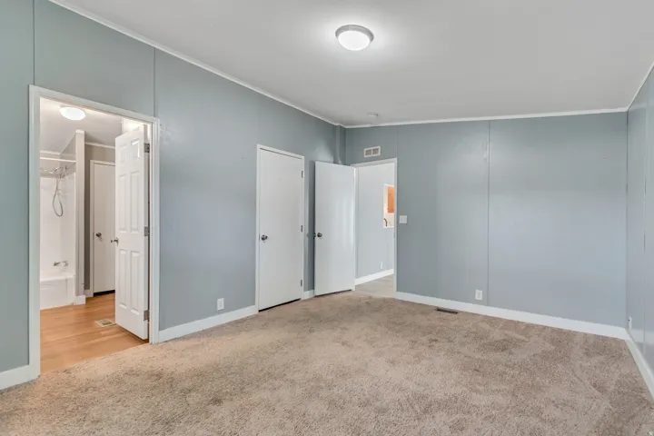 Carpeted room featuring light blue walls and white trim