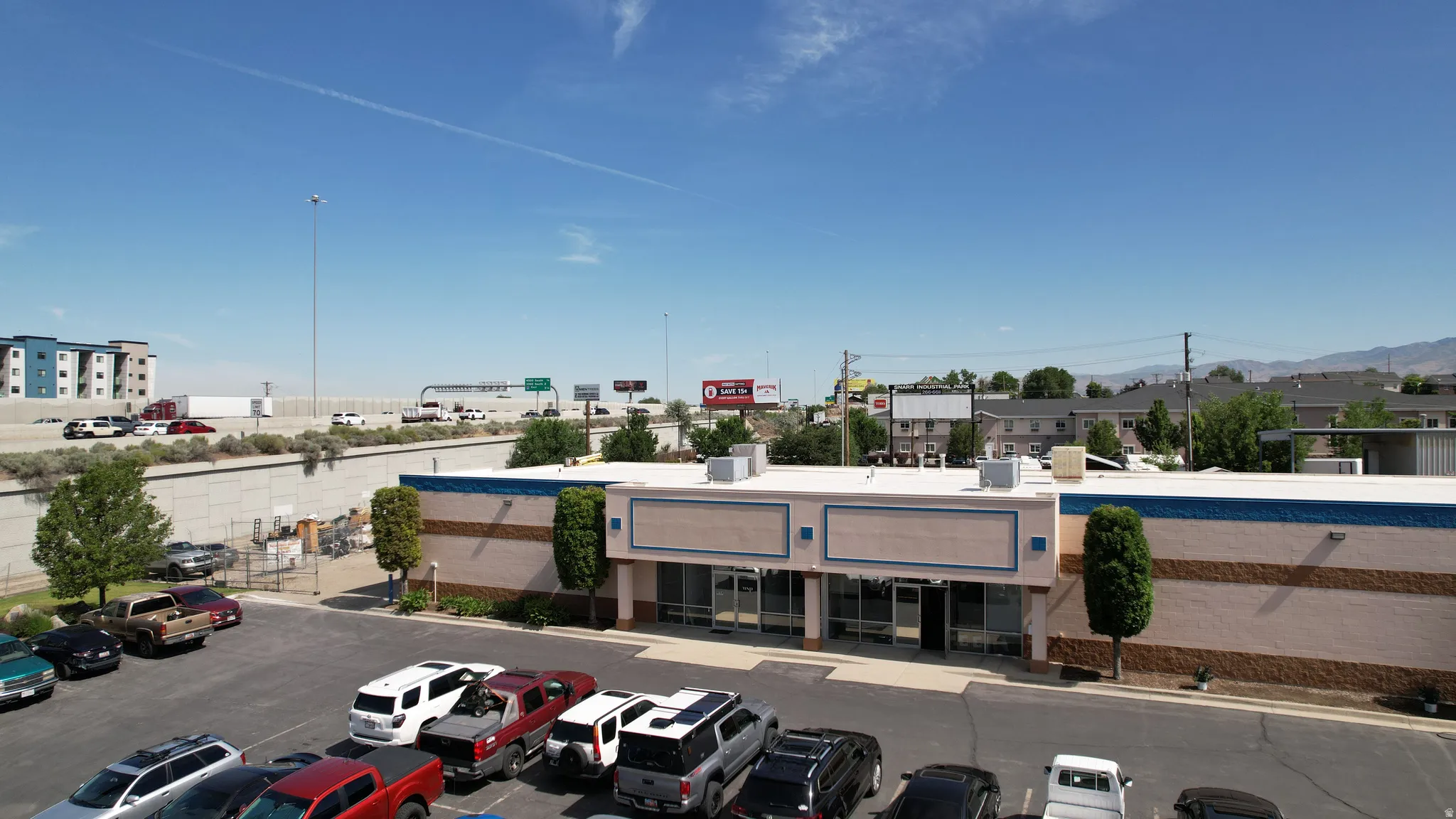 Commercial building featuring a large parking area, multiple storefront entrances, and prominent exterior signage space