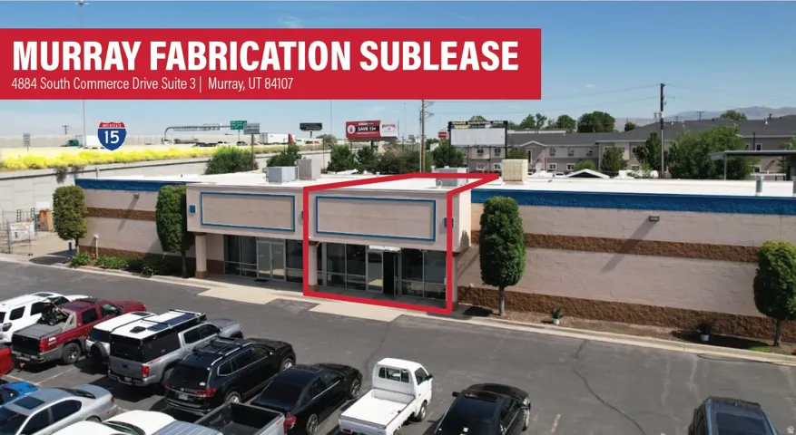 Commercial storefront with large window displays and an expansive paved parking area