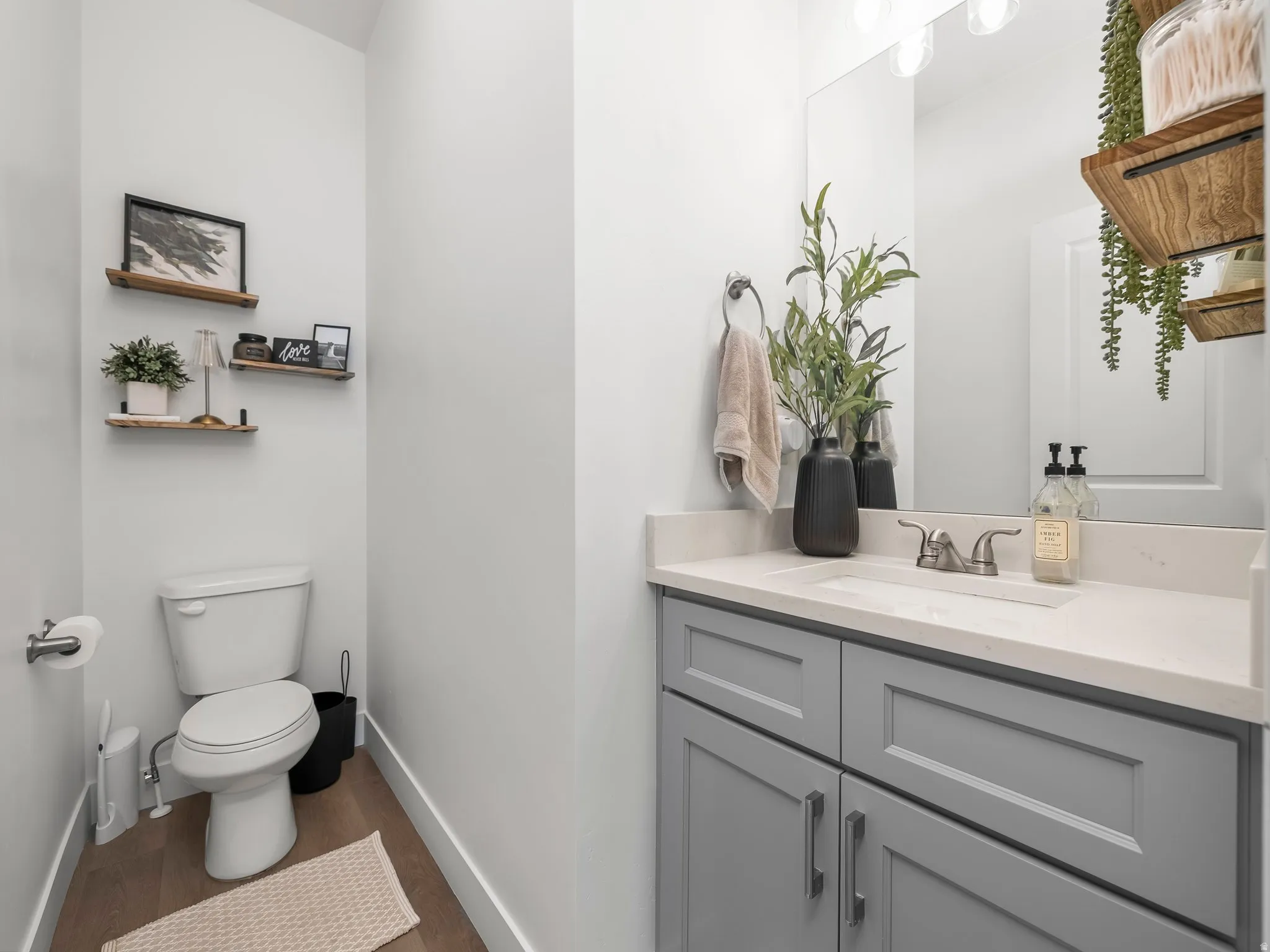 Powder room featuring a single vanity with gray cabinetry and a light-toned countertop, an integrated sink, and a brushed nickel faucet