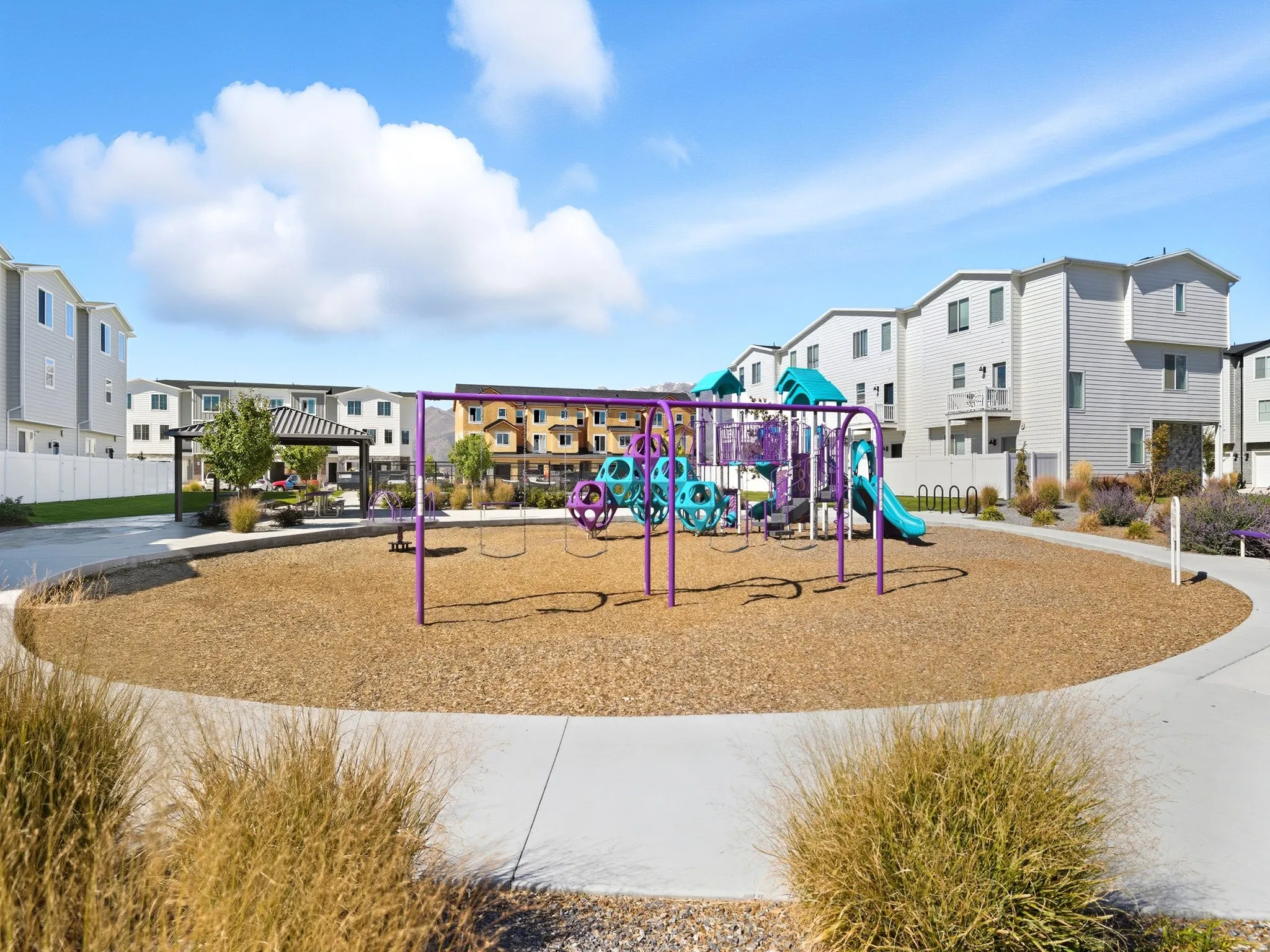 Community playground area featuring a colorful playset, swings, and slides