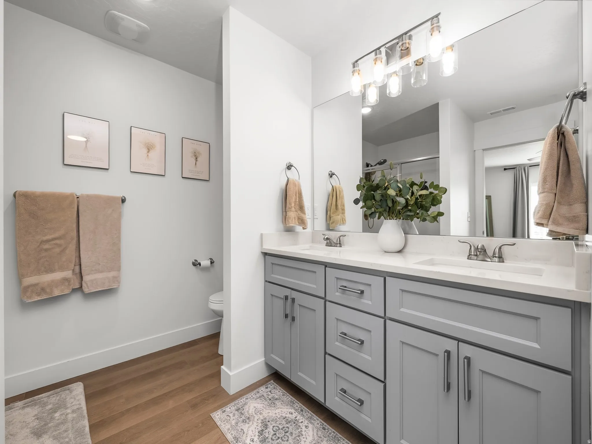 Double vanity with gray shaker cabinetry, chrome hardware, and white countertops