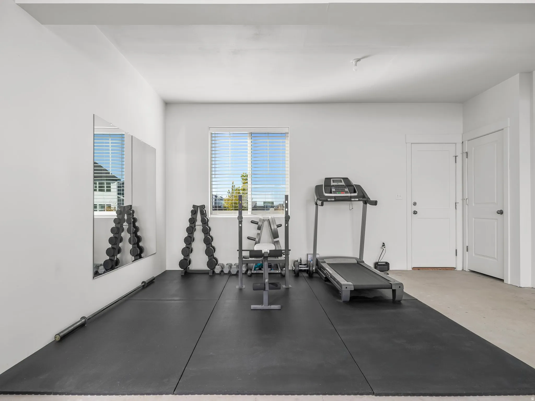 Dedicated room featuring a full wall mirror, recessed window with blinds, and white interior doors