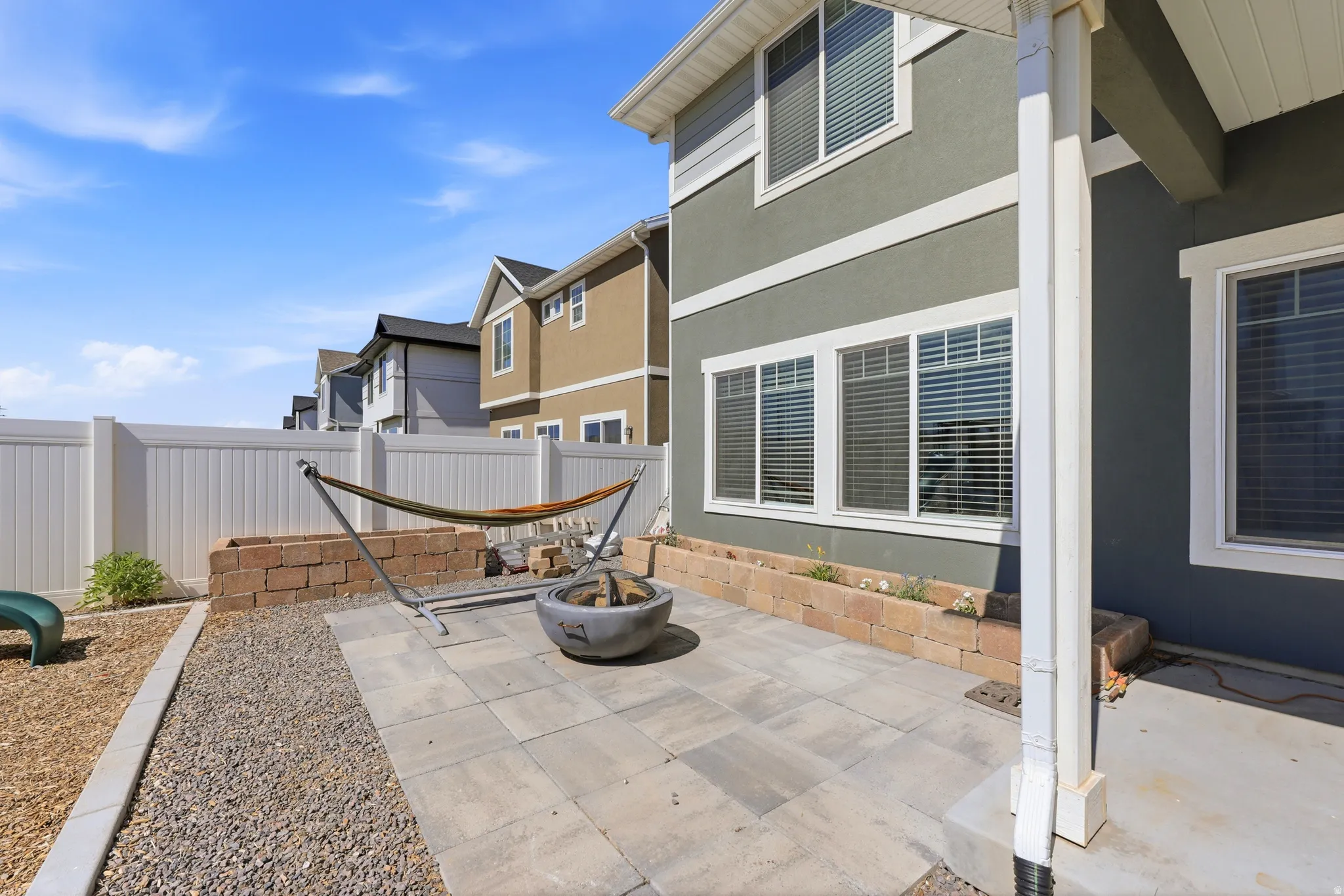 Expansive patio featuring paver stones, a gravel path, and a built-in stone planter