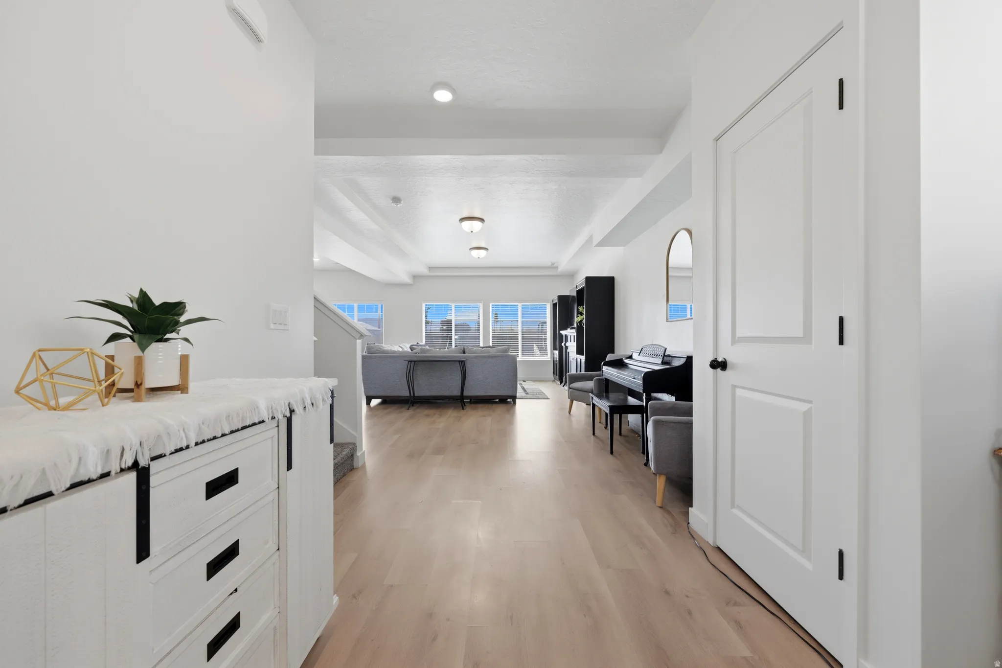 Bright interior hallway featuring wood-finish flooring, white walls, and recessed lighting