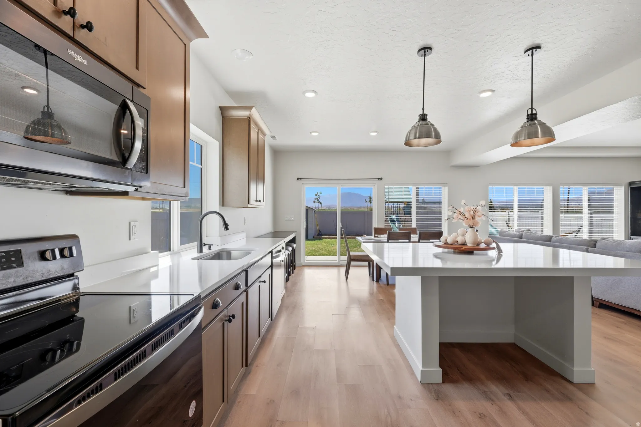 Open-concept kitchen with wood-finish flooring and a white countertop island
