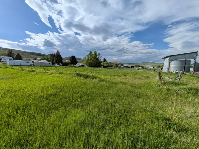Expansive grassy lot featuring a distant mountain range backdrop