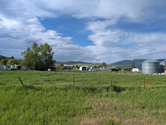 Expansive green field with distant mountain range backdrop