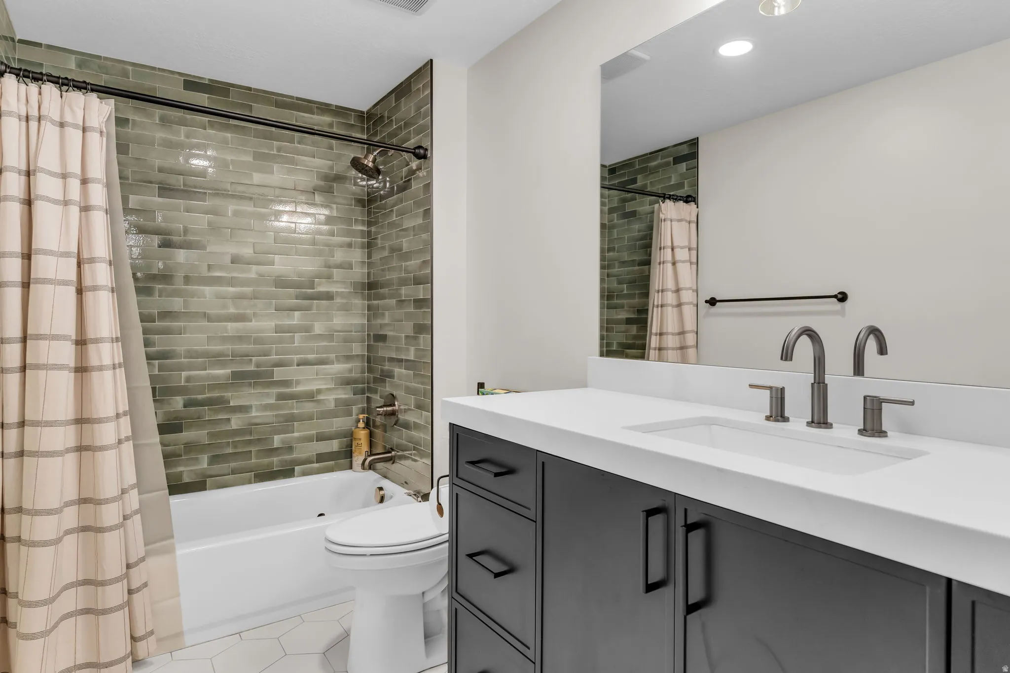 Bathroom featuring a vanity with dark cabinetry, white countertop, and brushed nickel fixtures