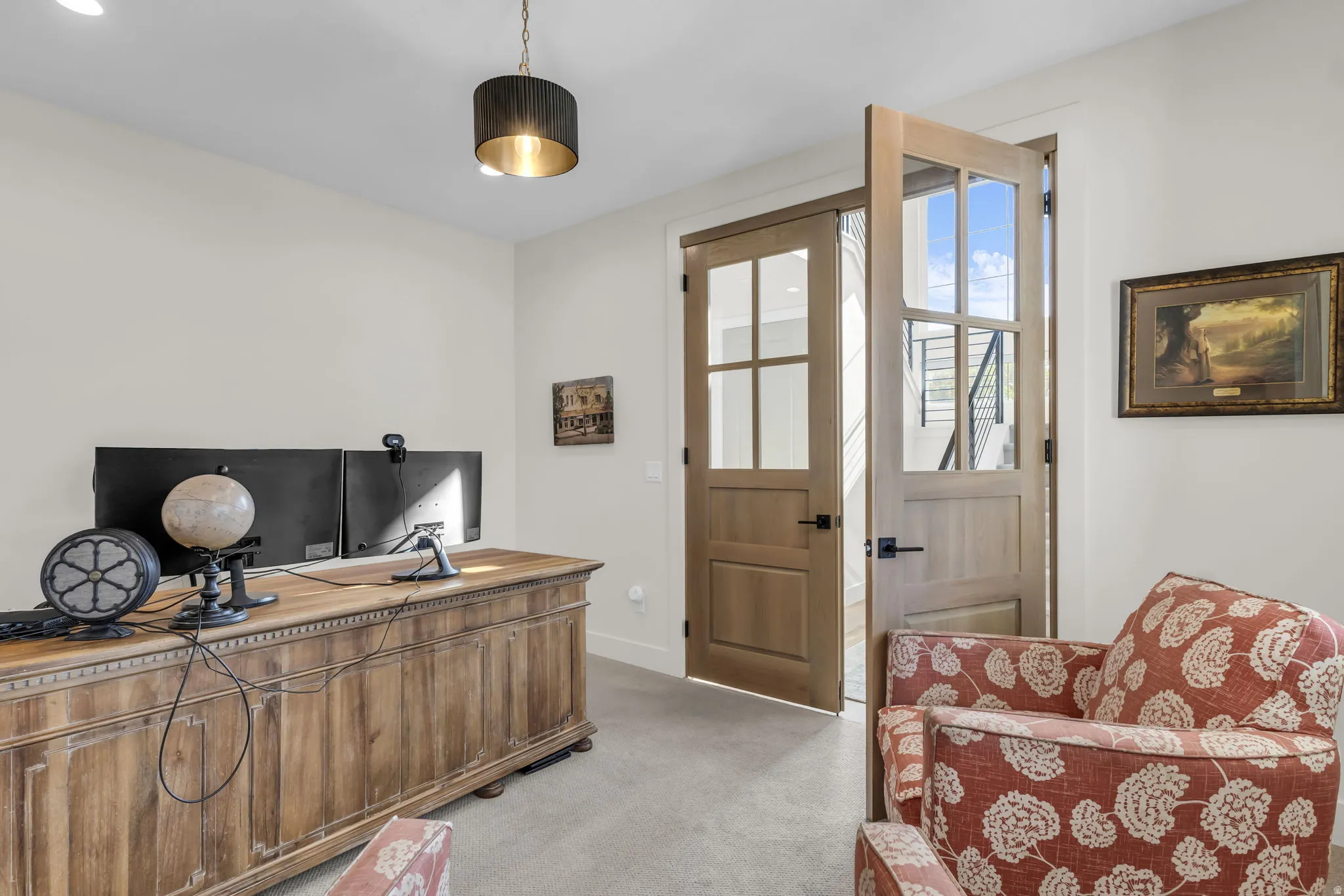 Room with light wood-finish French doors featuring clear window panes and dark hardware