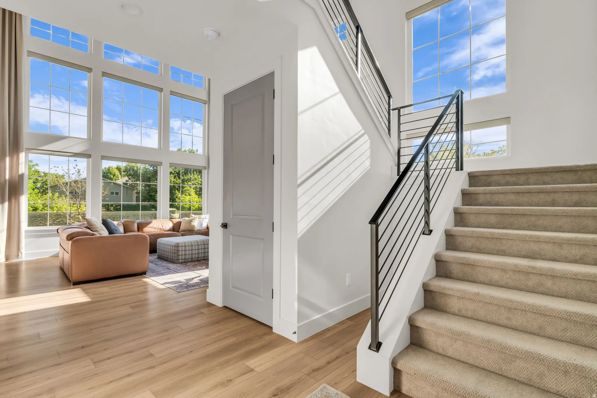 Staircase with contemporary black metal railing and carpeted treads