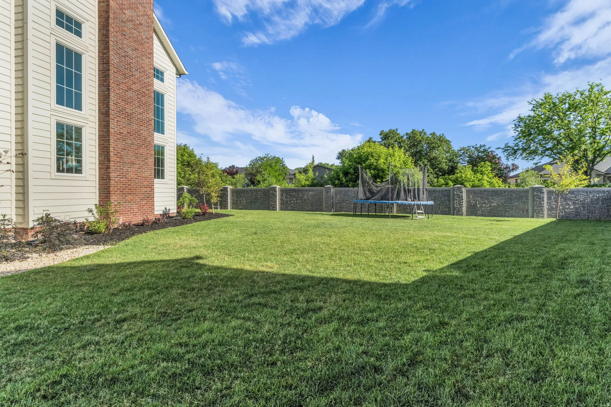 Expansive green lawn surrounded by a stone-clad perimeter wall
