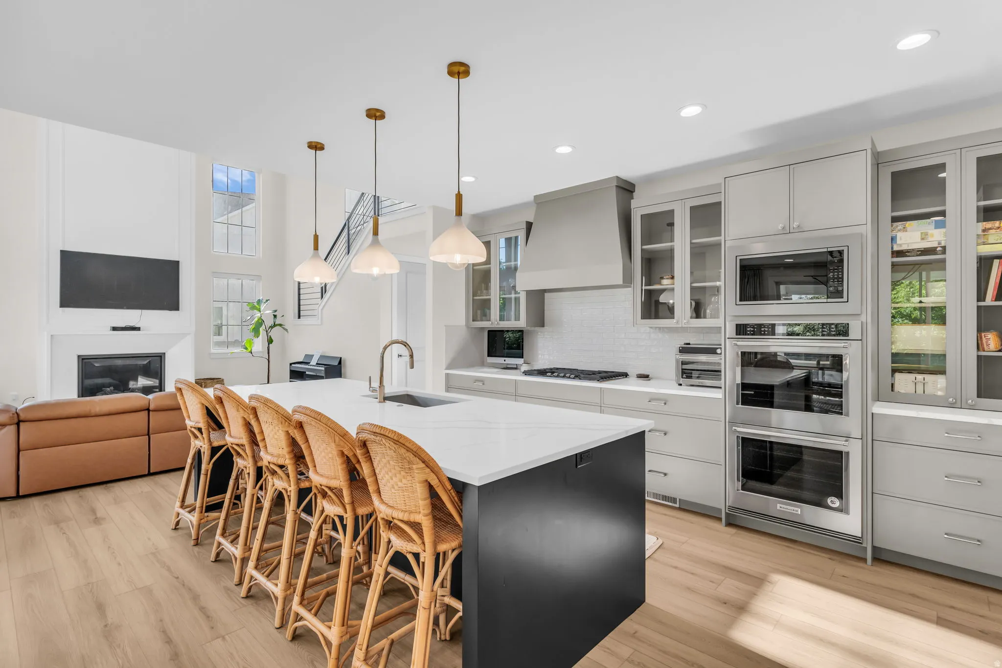 Gourmet kitchen with white subway tile backsplash, stainless steel appliances, and a large central island featuring a white countertop