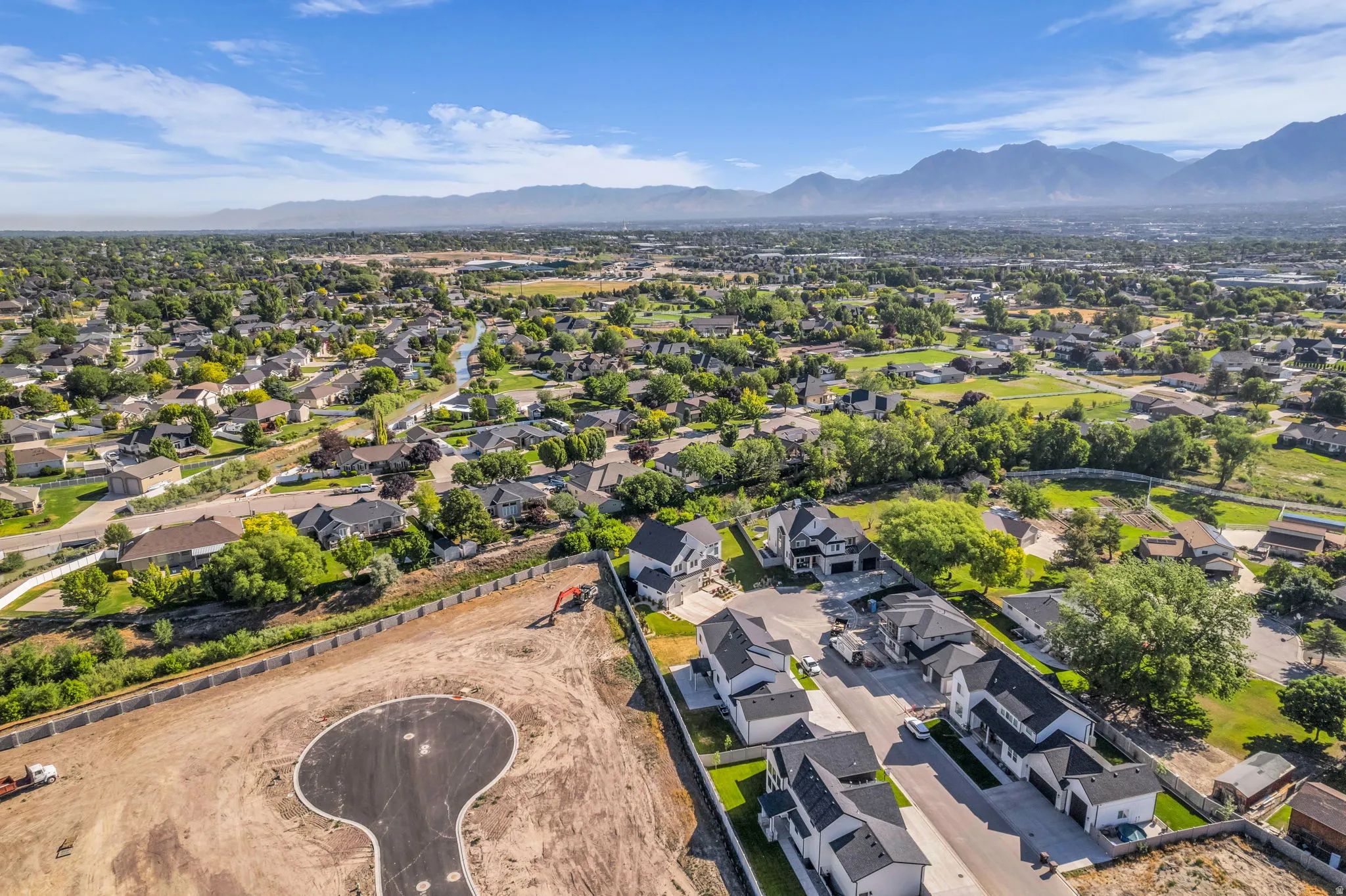 Expansive development land featuring a newly paved cul-de-sac and mountain range backdrop
