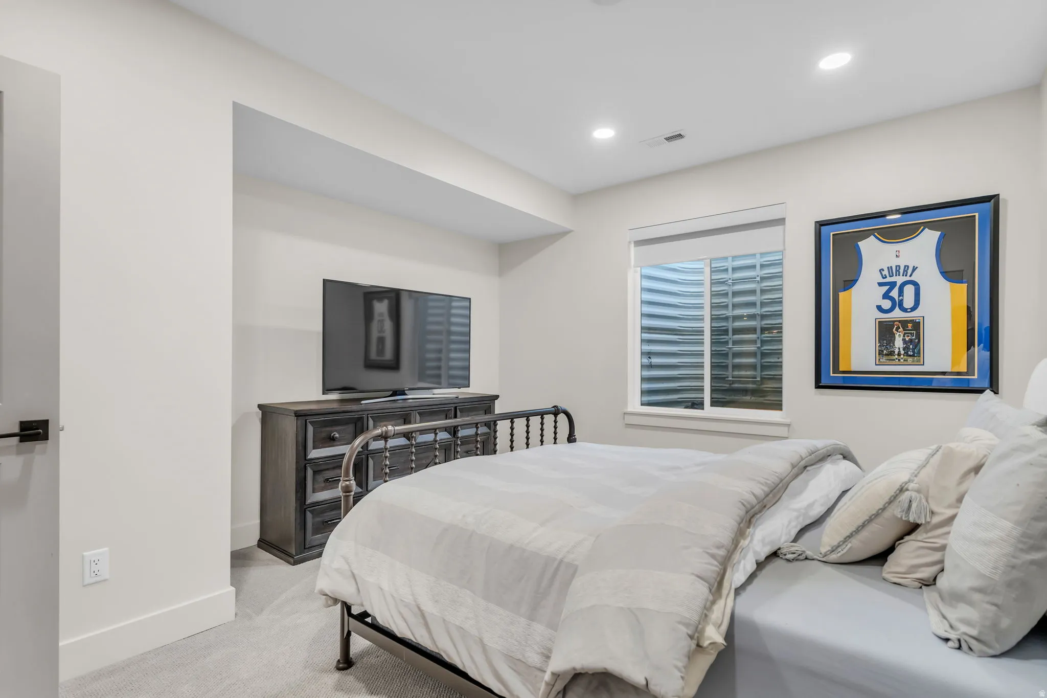Recessed lighting illuminates a neutral palette room with light gray walls