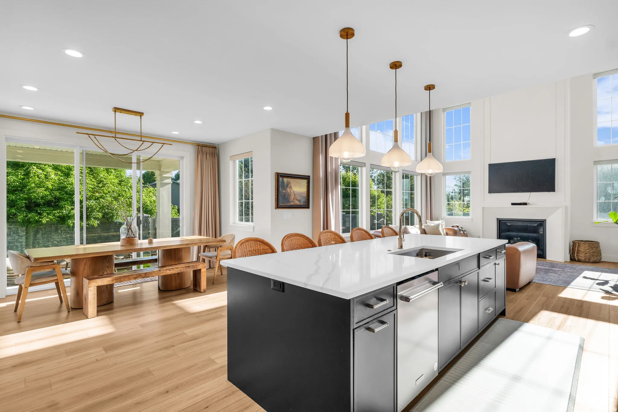 Spacious kitchen island with a white countertop and integrated sink, accompanied by pendant lighting
