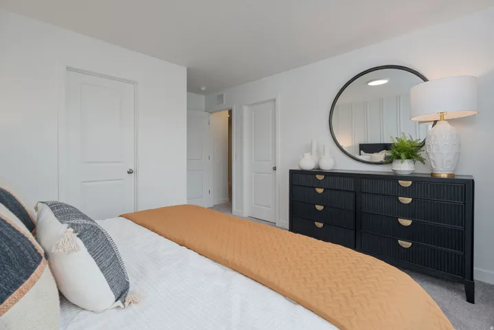 White interior walls with a round black-framed mirror