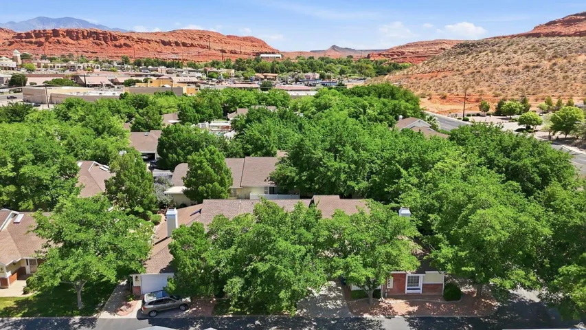 Residential buildings featuring pitched roofs and mature green trees