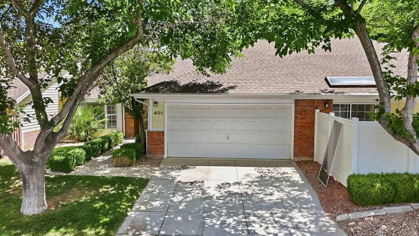 Front exterior featuring a two-car garage, brick accents, and a light-colored façade