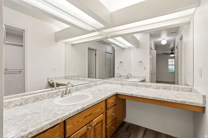 Bathroom vanity featuring dual inset sinks and brushed nickel faucets set into a light-toned countertop