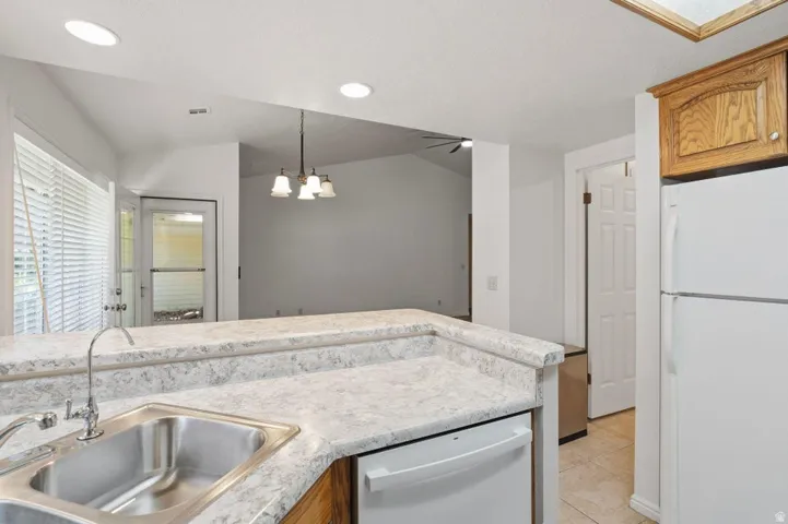 Kitchen featuring a double stainless steel sink, laminate countertops, wood cabinetry, and a full-size refrigerator