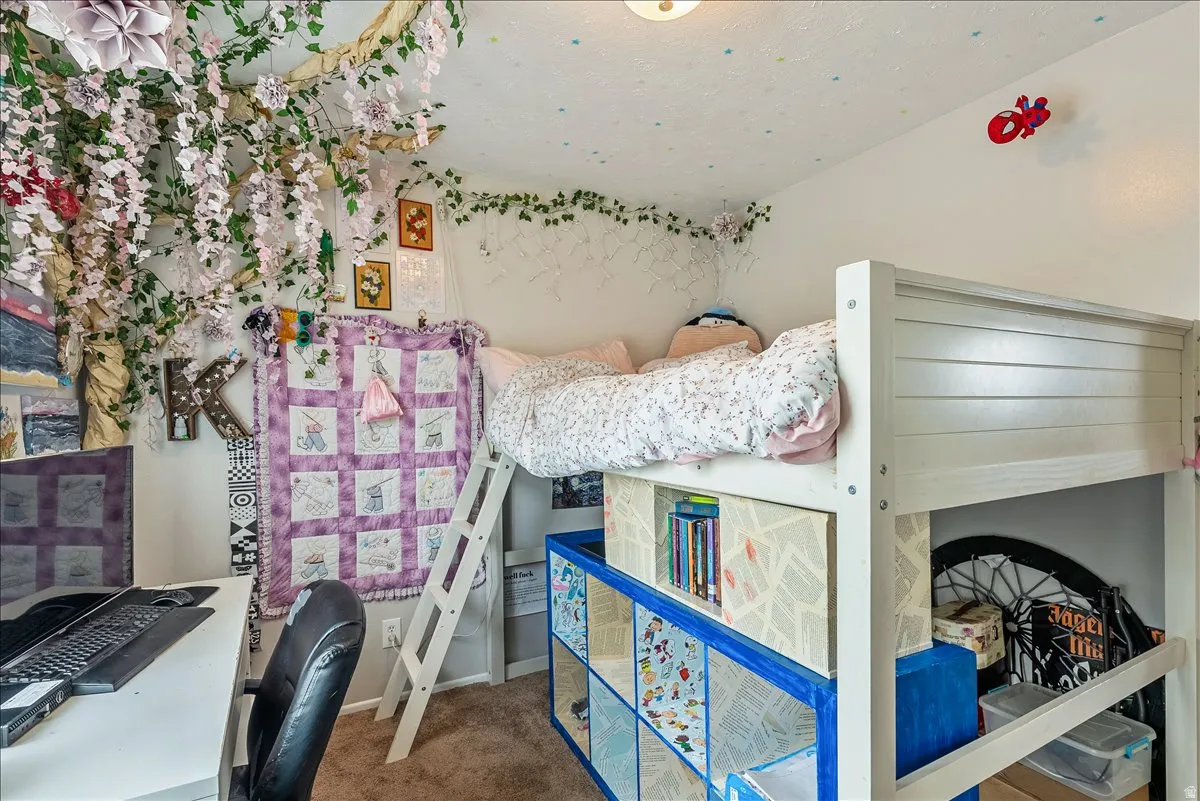 White bunk bed with integrated shelving, a built-in ladder, and carpeted flooring