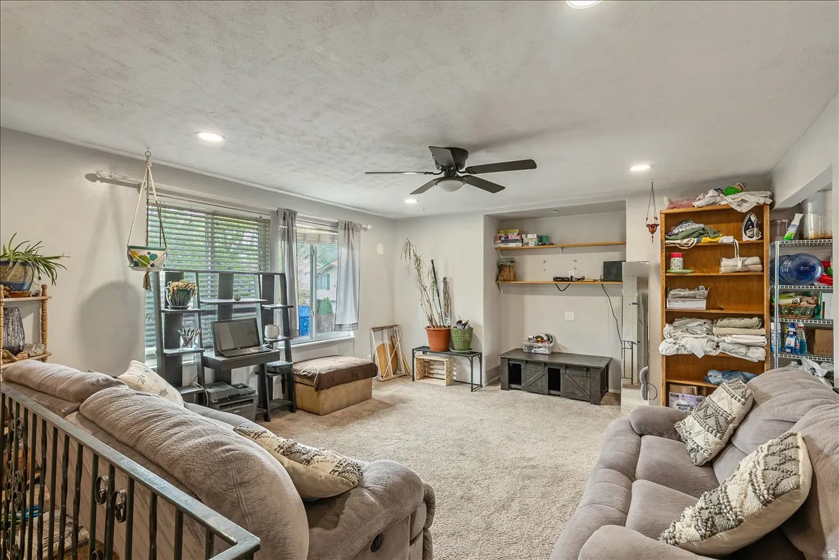 Carpeted living space featuring recessed lighting and a ceiling fan