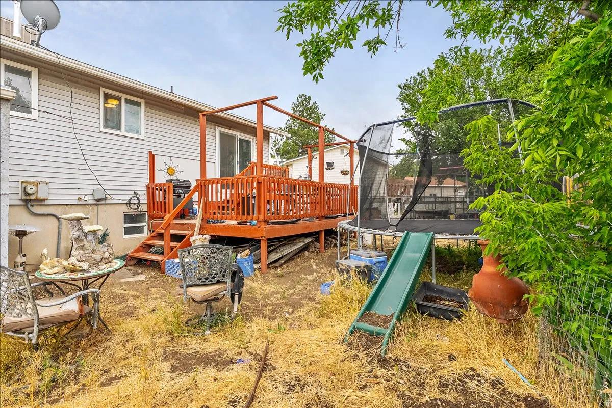 Rear exterior with light gray siding and a wooden deck