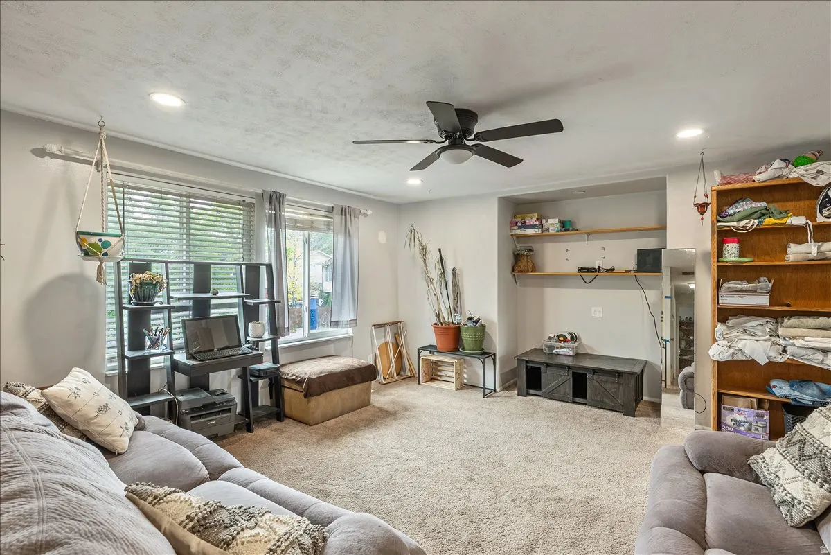 Carpeted living space featuring recessed lighting and a ceiling fan