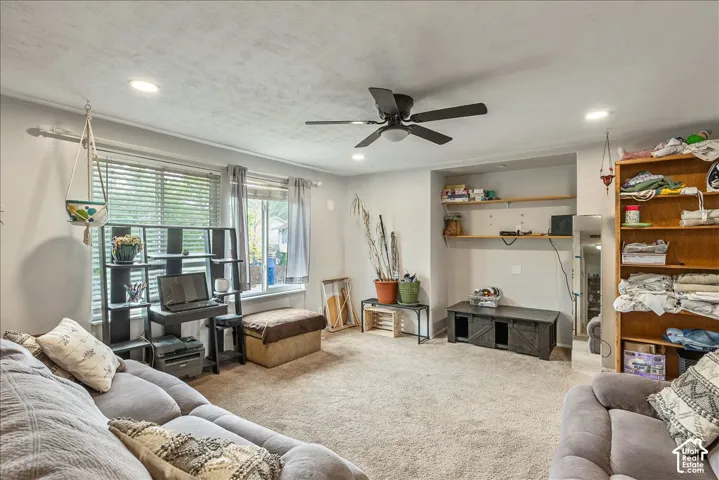 Carpeted living space featuring recessed lighting and a ceiling fan
