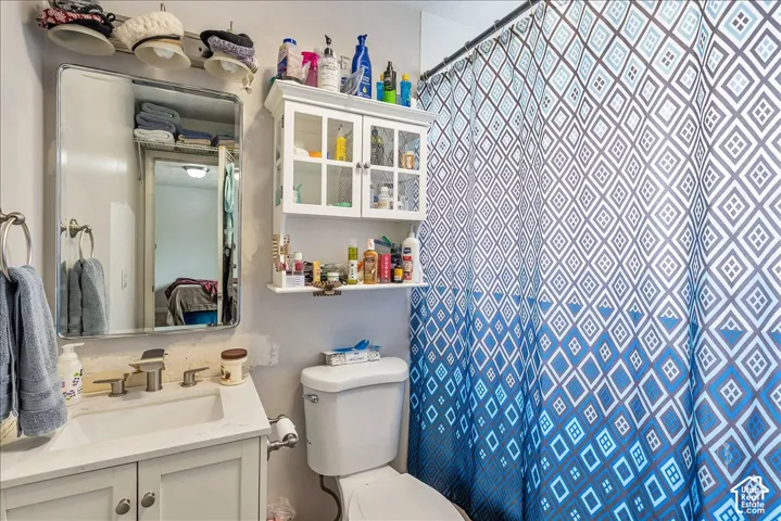 Bathroom featuring a white vanity with an integrated sink, polished chrome faucet, and rectangular mirror with overhead lighting