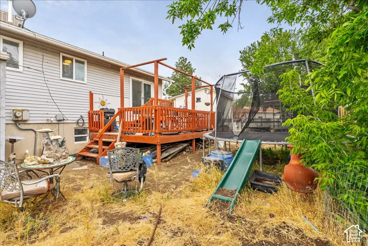 Rear exterior with light gray siding and a wooden deck