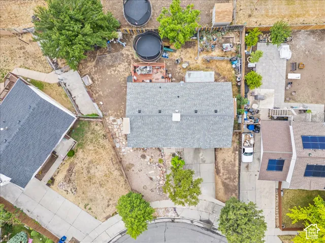 Residential property with a gray shingle roof, a paved driveway, and an expansive backyard area